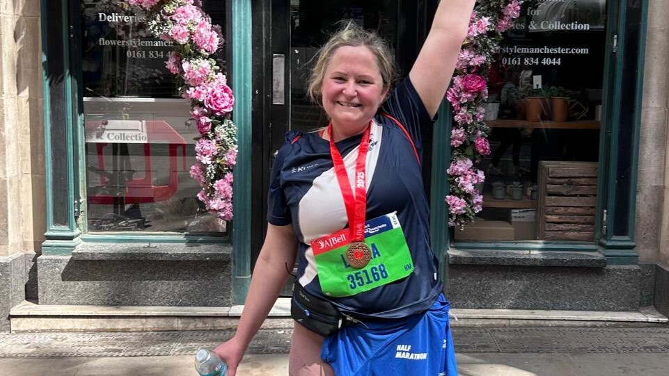 Photo of Laura having finished the marathon in front of a flower display