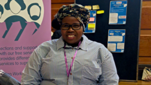 Photo of Stella sitting at a Centre 70 outreach stall