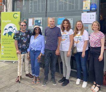 Photo of C70 staff, trustees and volunteers outside the office with Helen Hayes MP