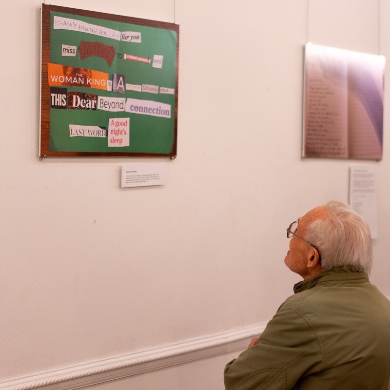 Back of person&#39;s head looking at a collage picture on the wall