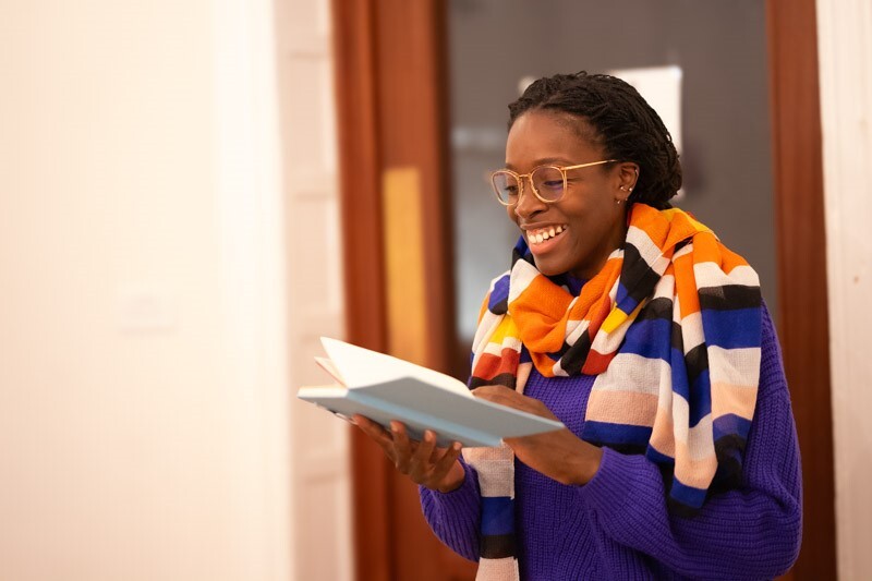 Woman smiling and reading from Maternal Journal 